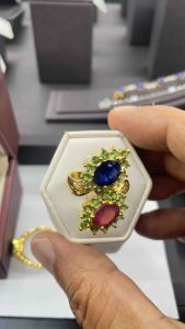 แหวนเงิน 925 ประดับด้วยพลอยน้ำเงินและทับทิมเจียระไนทรงวงรี ล้อมรอบด้วยพลอยซาโวไลท์และพลอยบุษราคัม