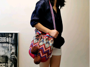DaVee Handmade Crochet Raffia Bucket Bag Tote Bag Shopping Bag Beach Bag with colorful zigzag pattern drawstring closure and brown pom-poms.