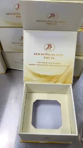 Kem dưỡng da ngày TMX X4 30g thiết kế sang trọng với nắp vàng phù hợp cho da nhạy cảm được trưng bày trên kệ gỗ với nền cảnh quan xanh mát.