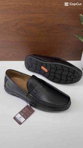 Giày da nam đen bóng dáng loafer với chi tiết khóa trang trí.