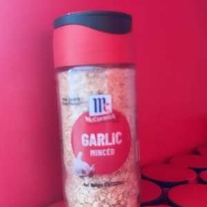 McCormick Garlic Minced 57g Small Bottle - Transparent glass container with red cap - Contains minced garlic - Net weight 57g (2oz) - New look same quality - Suitable for cooking and seasoning.