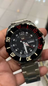 Seiko 5 stainless steel sports automatic Japan made watch with black dial and red accents.