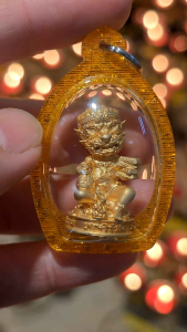 Gold pendant with five-eyed deity figurine in oval case.