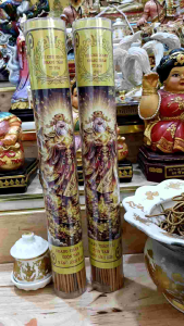 Nến hương vàng với hình ảnh thần linh đặt trên bàn thờ với lư hương và tượng thần linh.1 ống 100 cây.85k