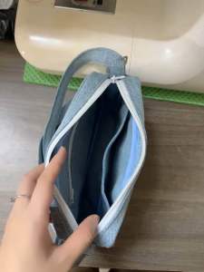 Túi xách nhỏ màu xanh denim với dây đeo vai thiết kế túi trước vải jean phù hợp cho các hoạt động hàng ngày.