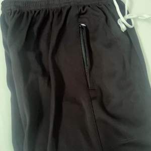 กางเกงวอร์มตะเข็บขายาวขาปล่อยมีสีดำและกลมเป็นสีพื้น