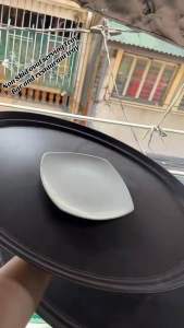 Oval rubberized service tray for restaurant and catering. Black color flat surface durable material suitable for serving. Kitchen setting.