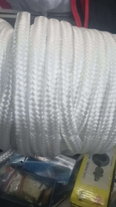Sold per yard tali ng duyan/White braided climbing rope with metal thimble displayed on glass surface.