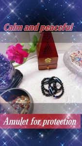 Black beaded bracelet with blue evil eye charm.