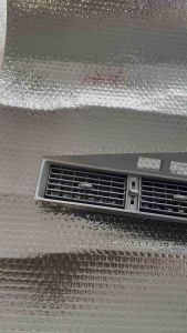Black car air vent with three rectangular openings and adjustable slats.
