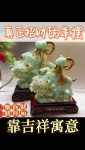 Green jade ram figurines with gold accents on wooden bases.