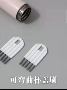 MULTIFUNCTION CUP LID BOTTLE GAP NYLON BRUSH White cleaning brush for bottle lid with metal bristles and ergonomic handle.
