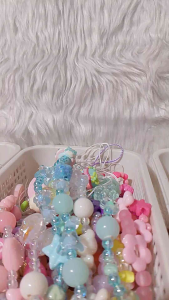 Beaded phone strap with assorted charm design and textured beads.