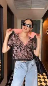 เสื้อซีทรูลูกไม้คอปกเชิ้ต แต่งกระดุมเปิดปิดได้จนถึงช่วงอก ชายเสื้อและปลายแขนแต่งลายขอบหยัก Tage::Mirror Sister