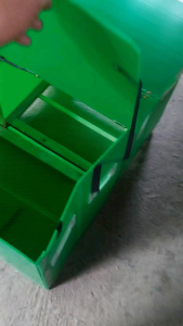 Collapsible chicken brooder cage with high quality plastic materials 50pcs capacity suitable for housing chicks placed on a dirt floor with electrical cords nearby.