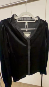 Black velvet blouse with ruffled trim V-neck and long sleeves.