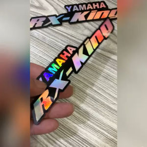 EMBLEM LOGO YAMAHA RX KING WARNA DASAR SILVER JIKA TERKENA CAHAYA MATAHARI / LAMPU BISA BERUBAH UBAH WARNA MENJADI WARNA PELANGI / SEPERTI BUNGLON