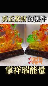 Two orange ram figurines with green and yellow accents on dark wooden bases.