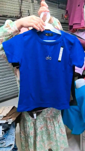 alo brand fulll length body hug / stretchable t-shirt overruns with logo in multiple colors fit for casual wear in various scenes.