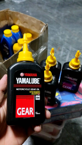 Yamaha Yamalube Motorcycle Gear Oil with yellow caps on grass.
