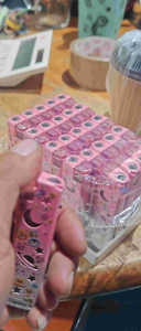 Pink lighters with space and cartoon designs on a white tray.