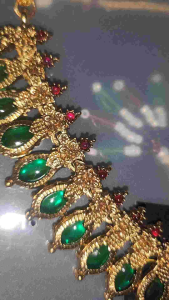 Gold necklace with green gemstones and matching earrings.