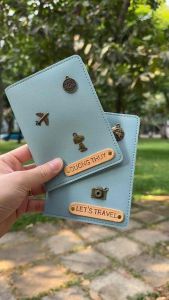 Bọc hộ chiếu màu xanh lam nhạt khắc tên theo yêu cầu charm decor đậm chất retro. Ghép charm thành tên chủ nhân độc đáo