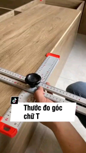 Thước chữ T đa năng 60cm dụng cụ đo lường dùng trong sửa chữa nhà cửa có núm điều chỉnh màu trắng đỏ đặt trên bệ đá.