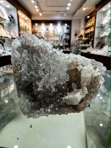 Clear quartz cluster with white calcite in mineral shop display