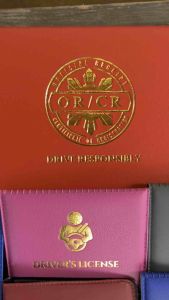 CAR MOTORCYCLE ORCR HolderICover Embossed with Gold Stamping. Fit for travel wallets and passport covers. Scene: Displayed on a wooden surface.