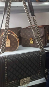 PRELOVED THRIFT BUNDLE Black quilted leather handbag with chain strap and metal clasp.