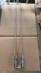 Stainless steel topload antenna with middle hole design 2 feet long featuring multiple connectors and a measuring tape for scale.