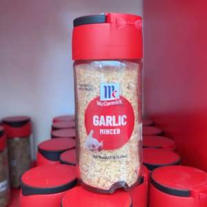 McCormick Garlic Minced 57g Small Bottle - Transparent glass container with red cap - Contains minced garlic - Net weight 57g (2oz) - New look same quality - Suitable for cooking and seasoning.