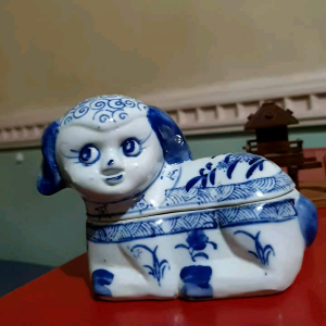 Blue and white porcelain dog-shaped box with floral patterns for trinkets.