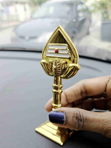 Gold and green car dashboard ornament with stand and base.