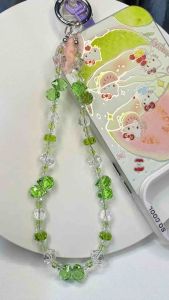 Colorful beaded phone strap with apple-shaped charms and clear beads.