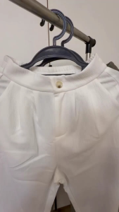 White wide-leg trousers with pleats and button closure. Suitable for casual or semi-formal occasions.