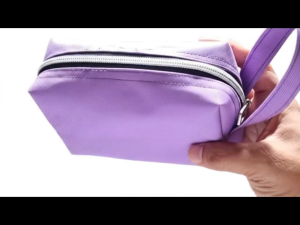 Purple fabric pouch with zipper and wrist strap for travel or daily use.