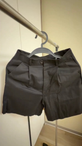 Pleated shorts with button closure and belt loops. Casual wear for summer.
