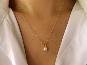 DaVee 14K Gold plated AK freshwater pearl necklace. Key attributes: delicate chain single pearl pendant gold plating. Fit/use: elegant accessory. Scene: worn with white shirt.