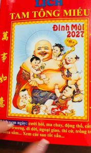 Lịch Tam Tông Miếu Đinh Mùi 2027 - Hình ảnh Phật Di Lặc bế trẻ em màu đỏ chữ vàng phù hợp xem ngày cầu mong may mắn bình an.
