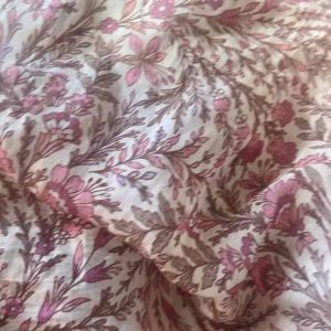 Floral patterned Batiste fabric with pink and brown leaves and flowers on off white background. Suitable for home decor and sewing projects.