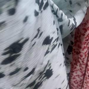 Powder blue and off white floral patterned fabric with abstract black spots. Suitable for summer dresses.