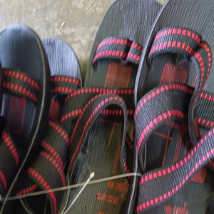 VKC Pride black and red crisscross strap sandal with toe loop and patterned sole.
