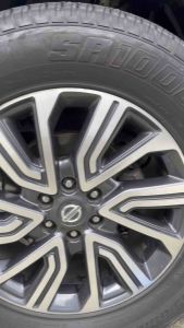 Brightenme Tire Cream Matte Finish for tires. Black bottle with nozzle. Suitable for automotive use. Displayed in a modern showroom setting.