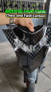 AEROX v2 carbon performance motorcycle fairing with checkered pattern and central mounting point on grass.