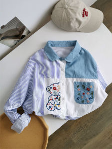 เสื้อเชิ้ตผู้หญิงแขนยาวทรงหลวมสไตล์ย้อนยุคปักลายดอกไม้สีขาวลายทางแนวตั้งผ้าเดนิมคอโปโลแขนยาว