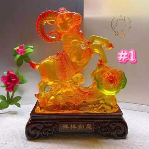 Two orange ram figurines with green and yellow accents on dark wooden bases.