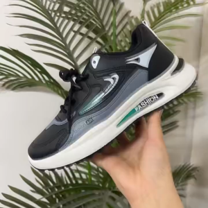 Black and gray sneakers with teal accents. Fashionable design. Suitable for casual wear. Displayed on a dark surface.