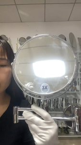 Chrome wall-mounted adjustable vanity mirror with extendable arm for close-up grooming.